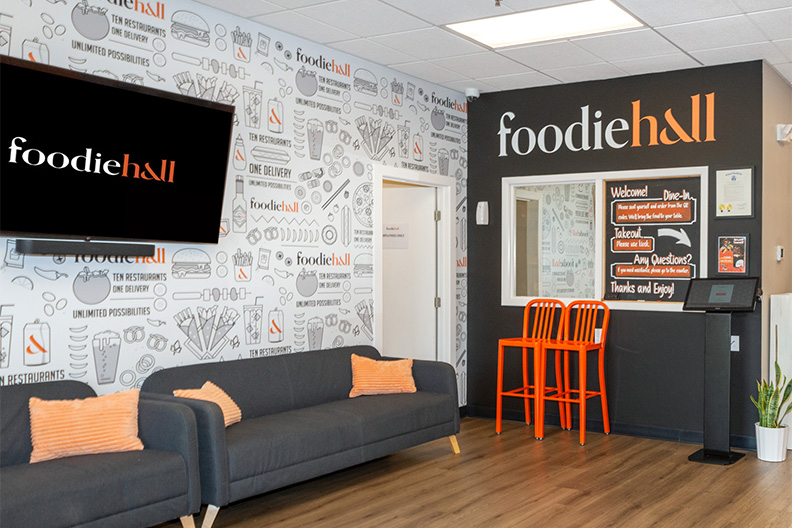 Interior of our food hall near Ashland, Cherry Hill with couches, TV, and ordering station.