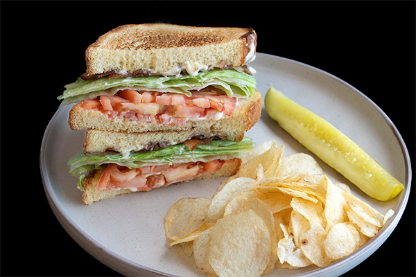 B.L.T. Sandwich with pickle and potato chips served at one of our multi cuisine restaurants near Ashland, Cherry Hill, New Jersey.