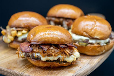 Four burgers prepared for Barrington take out.