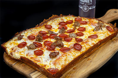 Detroit style pizza with pepperoni and sausage created for Ashland, Cherry Hill restaurant food delivery.